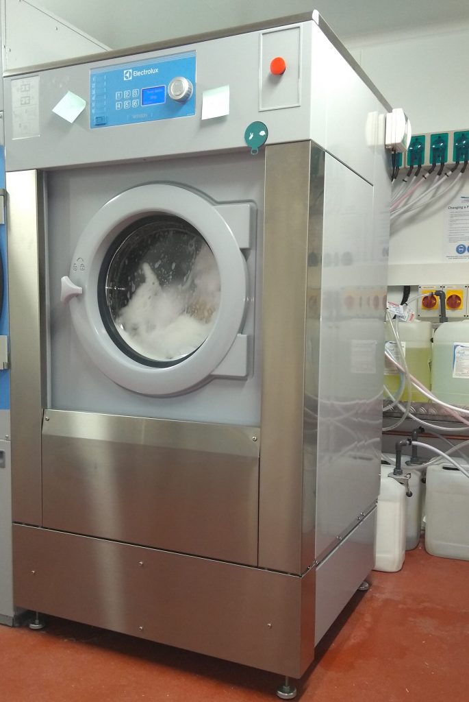 Commercial washing machine installed and turning Commercial Laundry